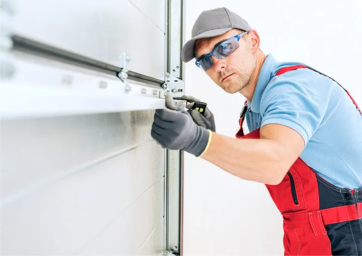Professional garage door installer makes precise measurements for a home garage door installation.